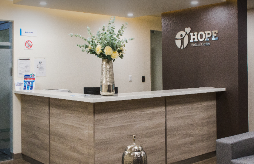 Reception of Hope Medical Center with a vase of flowers in front